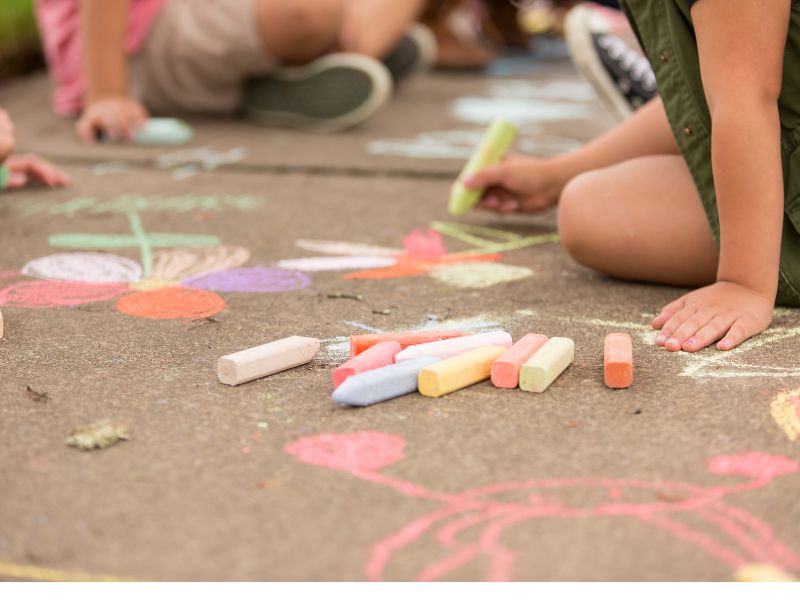 niños jugando con tizas de colores